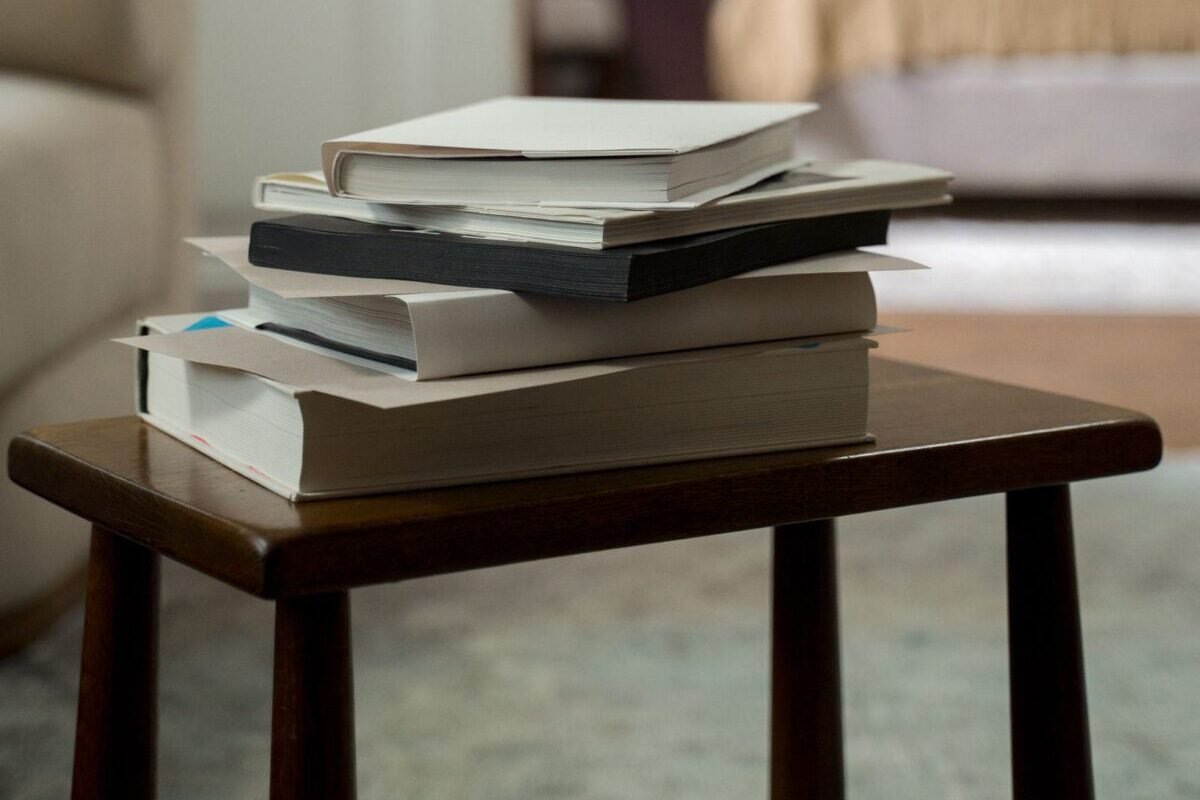 things to declutter small home fast – stack of books on a small bedroom side table