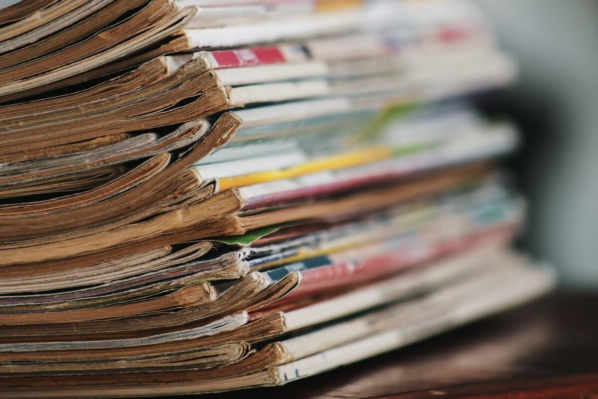things to declutter small home fast – tall stack of old magazines on a wooden table