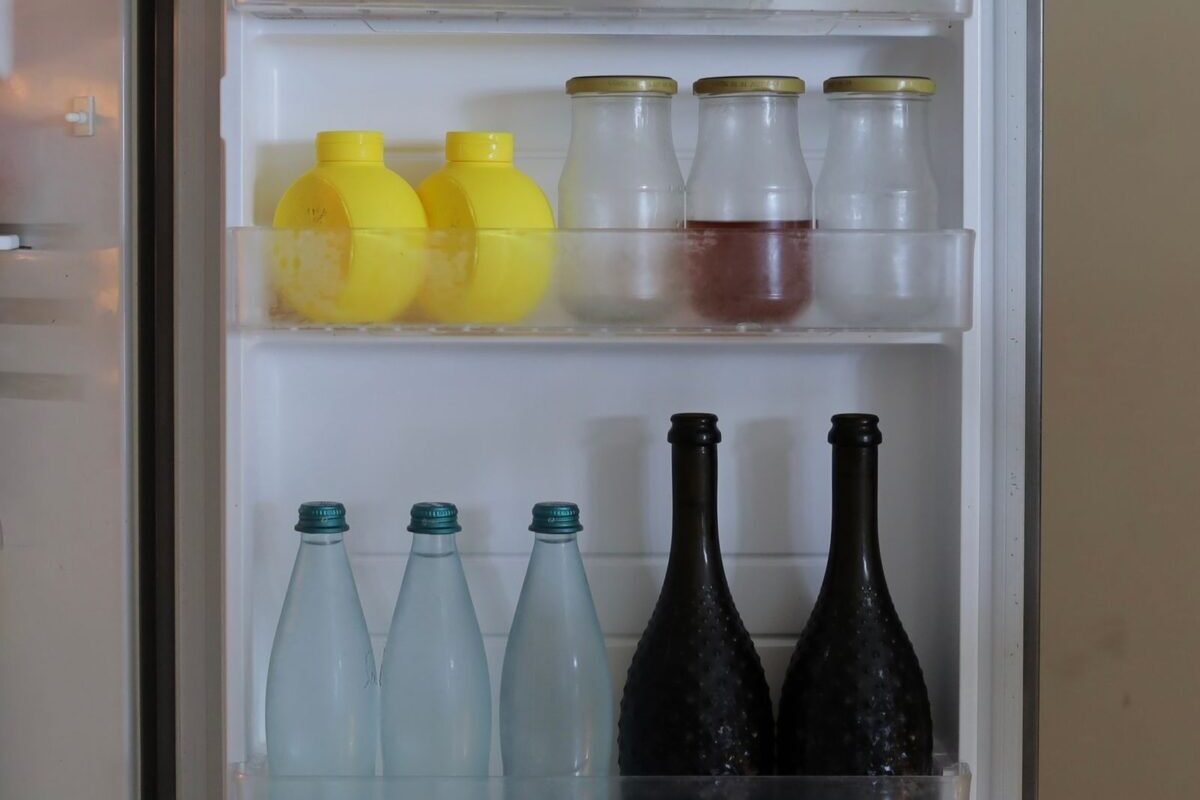 things to declutter small home fast – open fridge door shelves full of bottles and jars