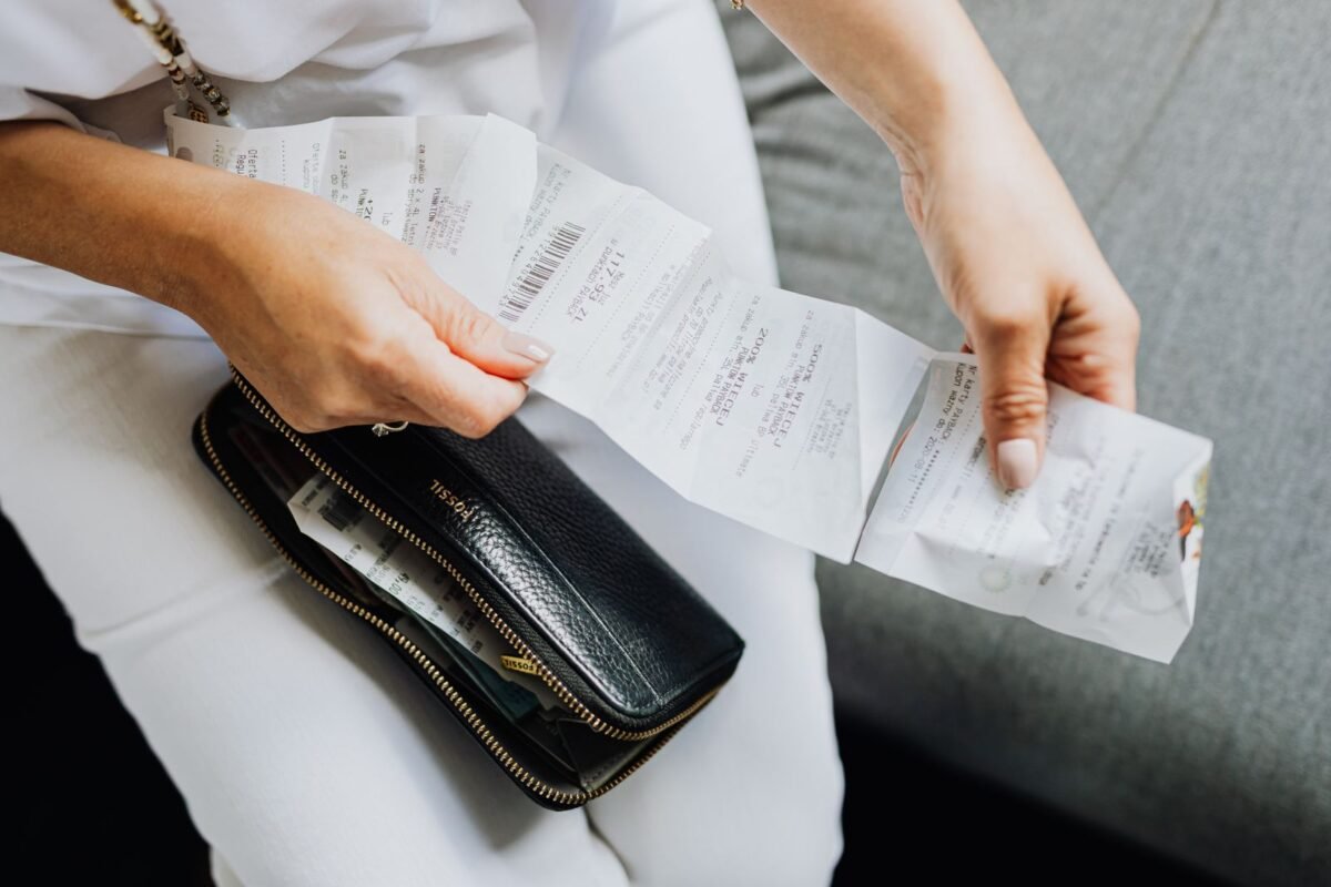 things to declutter small home fast – hands pulling old receipts out of a wallet