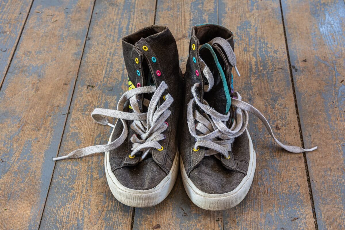 things to declutter small home fast – old worn sneakers on a wooden floor