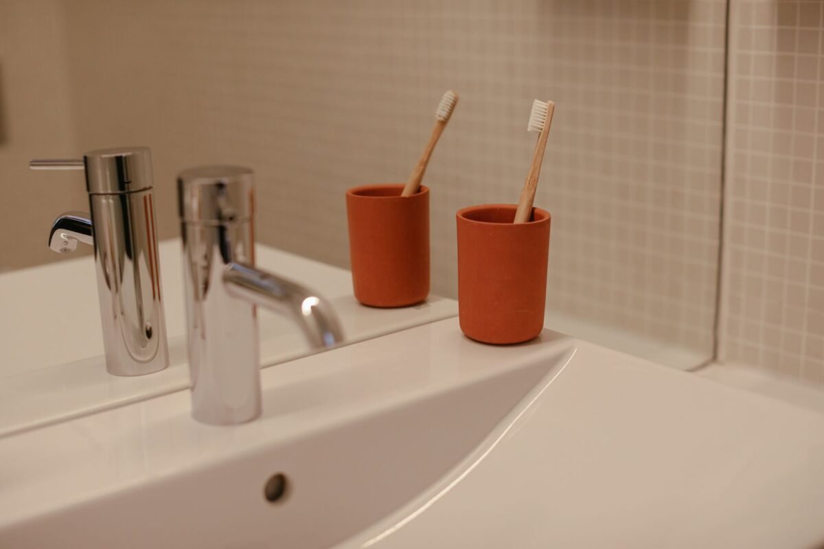 things to declutter small home fast – toothbrushes in red cups by a bathroom sink