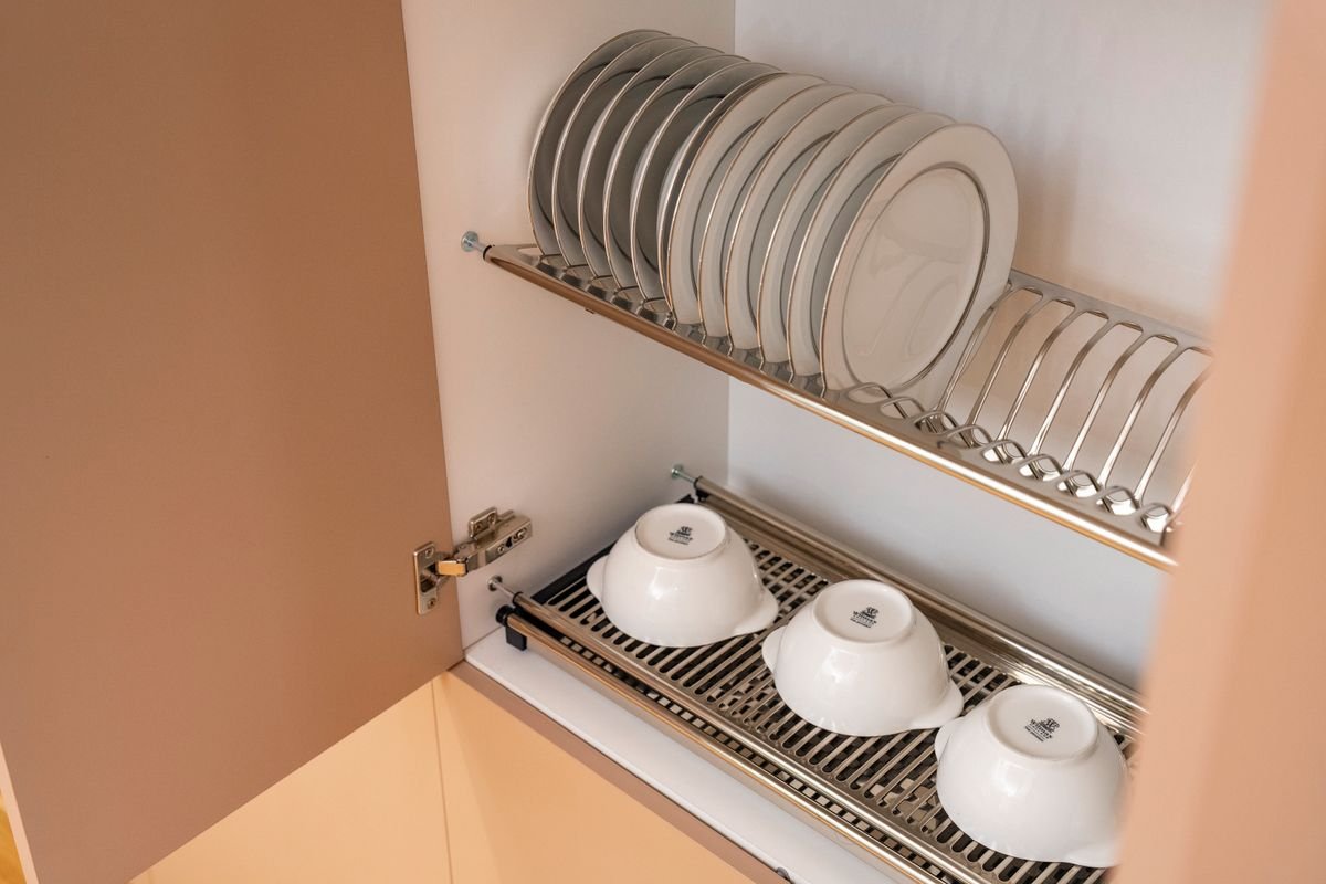 Kitchen cabinet organization ideas: plates and bowls filed upright in a rack inside a cabinet instead of stacked in piles.