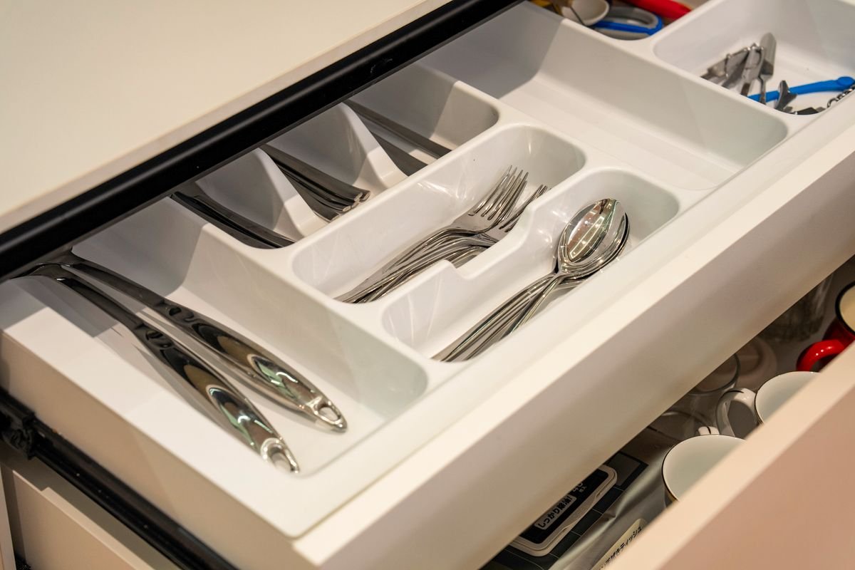 Kitchen cabinet organization ideas: silverware sorted in a divided organizer tray inside a kitchen drawer.