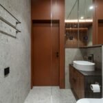 Small bathroom storage ideas no counter space: a compact modern bathroom with a wooden vanity, white sink, and glass shower