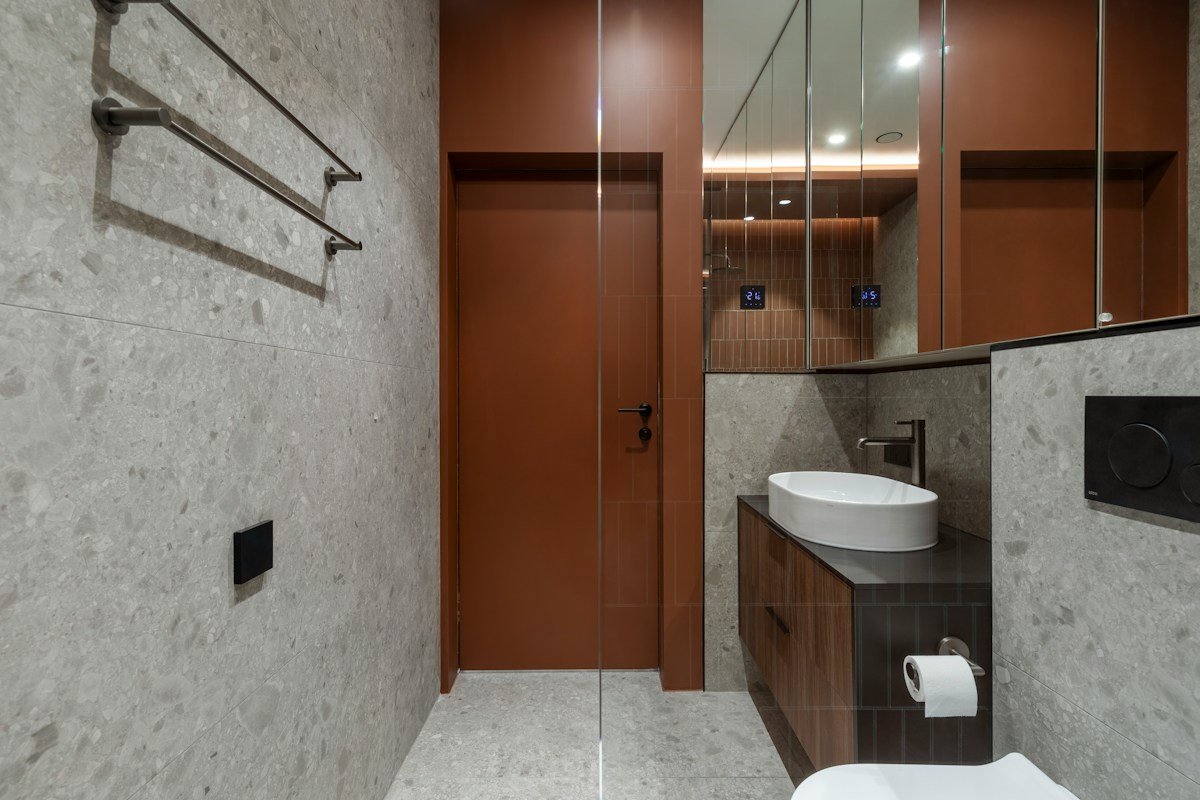 Small bathroom storage ideas no counter space: a compact modern bathroom with a wooden vanity, white sink, and glass shower
