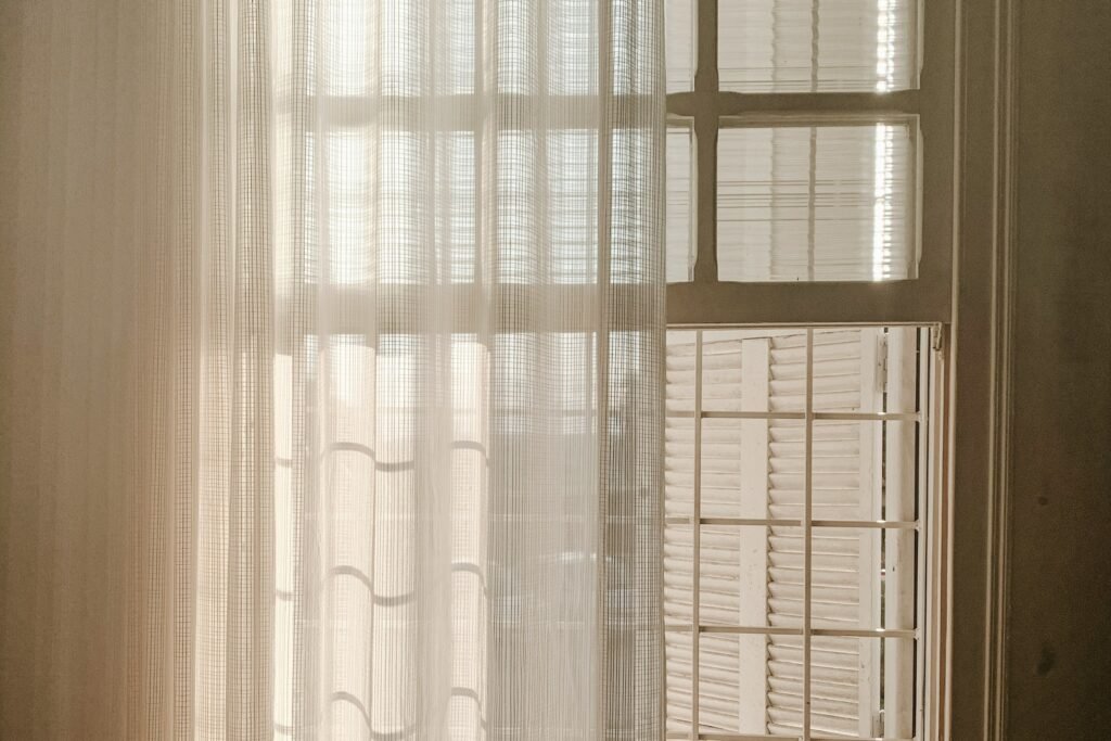 How to divide a studio apartment: sheer curtain hung as a soft room divider