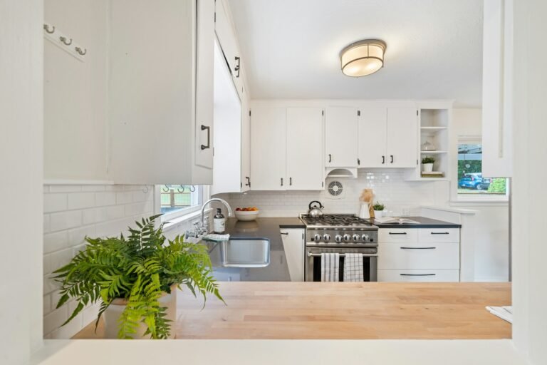 Small kitchen storage ideas for apartments with white cupboards and a compact stove